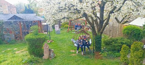 a group of people sitting on a swing in a yard at Margaréta Panzió in Sárospatak