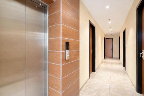 a hallway with a glass door in a hotel at Travinities Premier, Ujjain in Ujjain