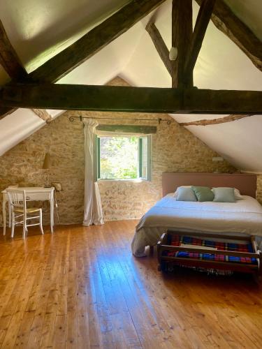 a bedroom with a bed and a table and a window at Les choses de la vie in Saint-Alvère