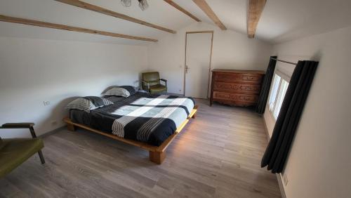 ein Schlafzimmer mit einem Bett und einer Kommode in der Unterkunft maisonette in Barjac