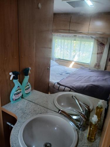 a bathroom with a sink and a bed at La Ventana - Jardin & Parking in Étretat
