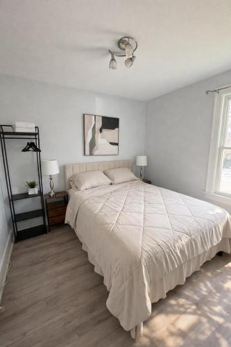 a bedroom with a large bed and two lamps at Black door bungalow in Windsor