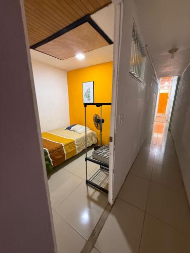 a bedroom with a bed and a yellow wall at Tico-living in Alajuela
