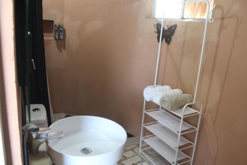 a bathroom with a white toilet and a sink at Hotel Kocai Izamal in Izamal