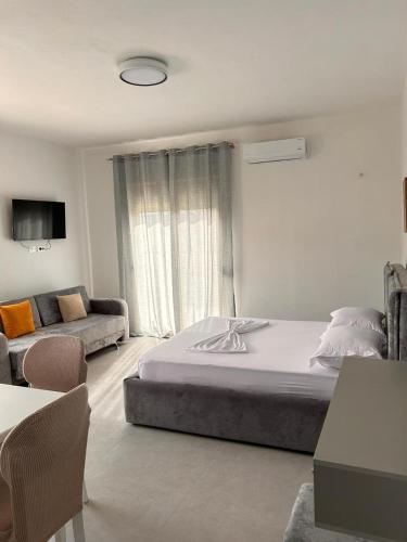 a bedroom with a large bed and a couch at Marina Oasis Apartments in Vlorë