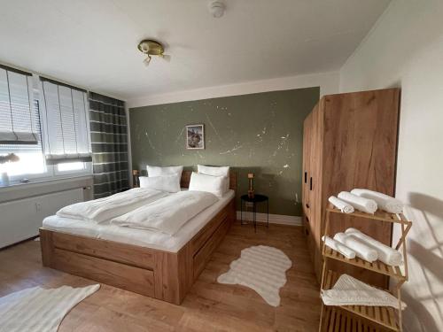 a bedroom with a large bed with white sheets at Ferienwohnung Stadt-Wald-Park in Bad Harzburg