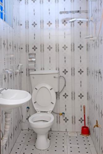 a bathroom with a toilet and a sink at Peak Motel in Kasese
