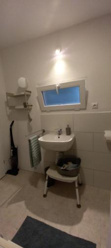 a white bathroom with a sink and a window at Szarotka in Brenno