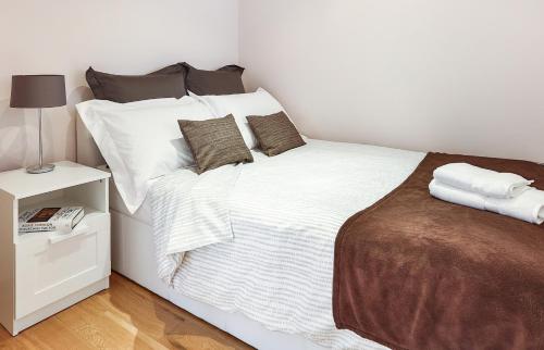 1 dormitorio con 1 cama con sábanas y almohadas blancas en Fabulous Apartment Central London, en Londres