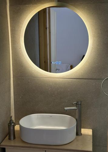 a sink in a bathroom with a round mirror at Evdilos Icaria 'Sto Plakostroto' by BRP-Properties in Evdilos