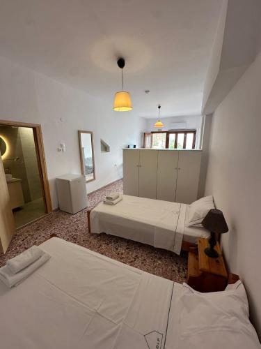 a bedroom with two beds and a mirror and a window at Evdilos Icaria 'Sto Plakostroto' by BRP-Properties in Evdilos
