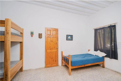 a bedroom with a bunk bed and a door at Avellanas Surf Hostel in Playa Avellana