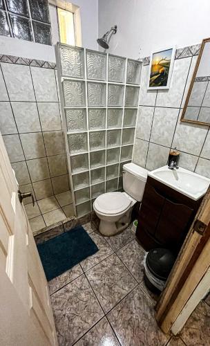 a bathroom with a toilet and a sink at Avellanas Surf Hostel in Playa Avellana