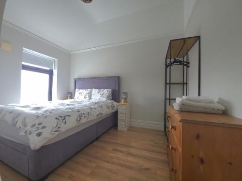 a bedroom with a bed and a mirror on a dresser at The Wild Atlantic Townhouse in Enniscrone