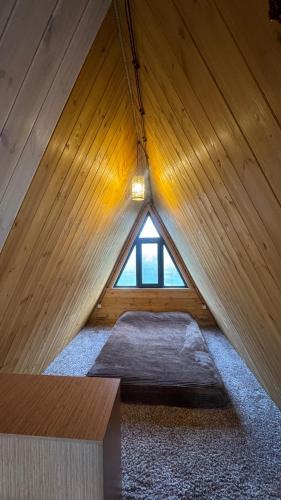 a attic room with a window and a mattress at Ditaket Dilijan in Dilijan