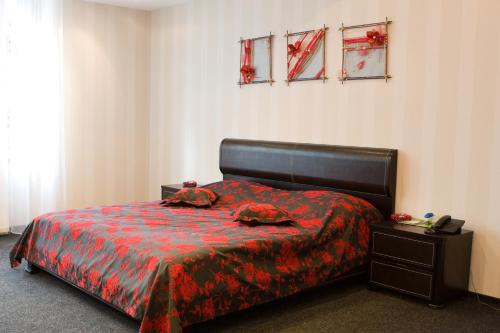 a bedroom with a bed with a red blanket at Hotel Complex Zelenyi Gai in Kopachuvka
