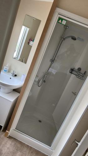 a bathroom with a shower and a sink at Crichtons Caravan at Haven Seton Sands in Port Seton