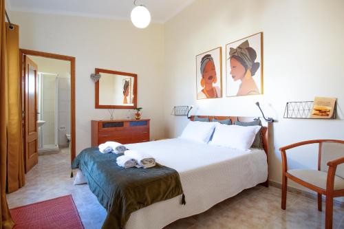 a hotel room with a bed and a chair at Casa Laranjal in Albufeira