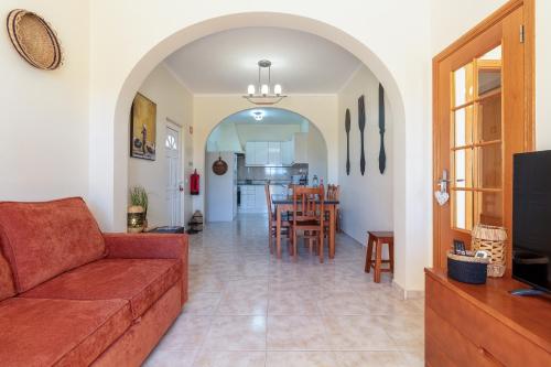 a living room with a couch and a dining room at Casa Laranjal in Albufeira