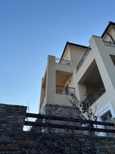 Ein Gebäude mit Treppe und blauem Himmel im Hintergrund in der Unterkunft August Andros in Ándros