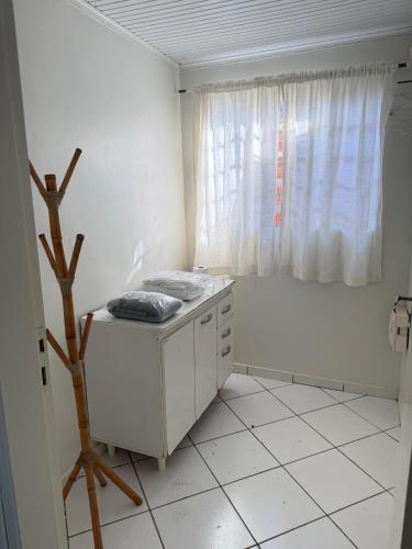 a white room with a table and a window at Repouso Tranquilo in Assis