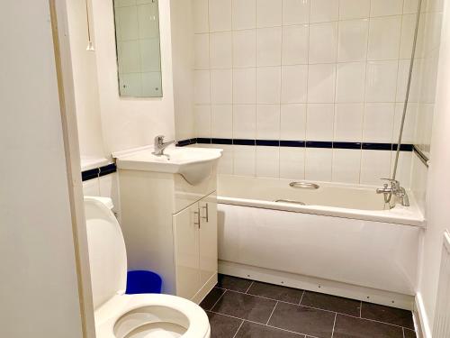a white bathroom with a toilet and a sink at 2 Bedrooms Modern Central London Apartment, Full Kitchen, 5 minutes Tube Station in London