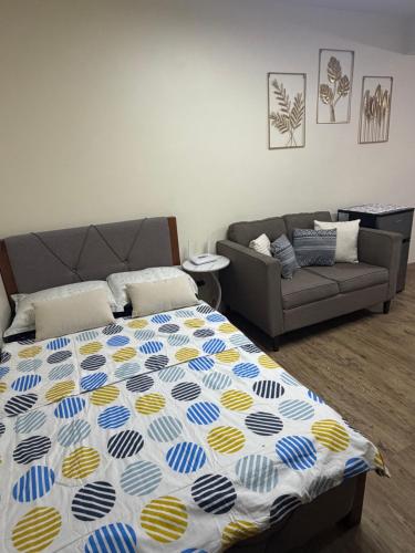 a bed in a living room with a couch at Fullerton suites C homestay in Silang