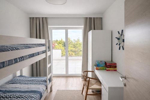 a bedroom with a bunk bed and a desk with a desk at Theodora Residence in Balatonalmádi