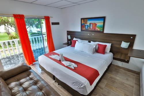 a bedroom with a large bed and a couch at Hotel terranova in Melgar