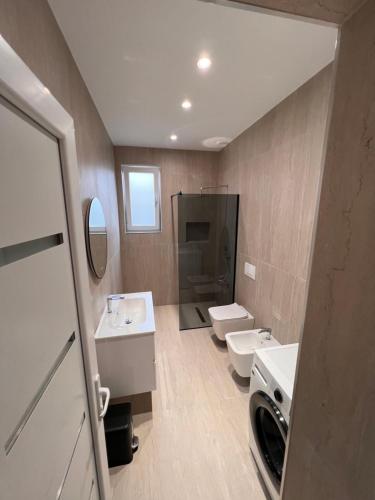 a bathroom with two sinks and two toilets at Aron apartments in Tirana