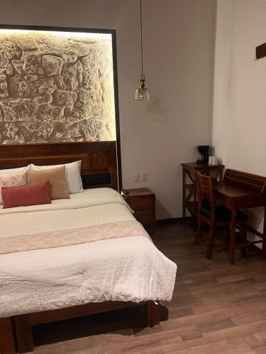 a bedroom with a bed and a table and a desk at Navarrete 63 Hotel in Morelia