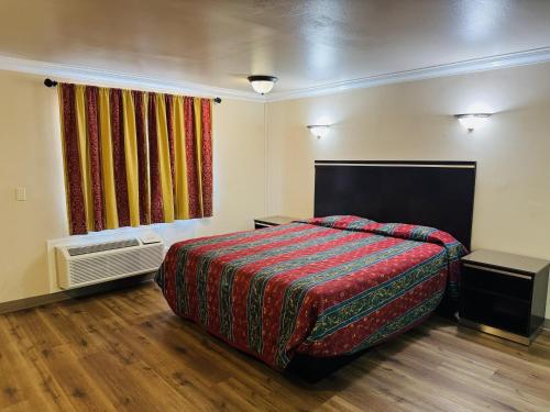 a bedroom with a large bed and a window at Imperial Inn & Suites in Norwalk