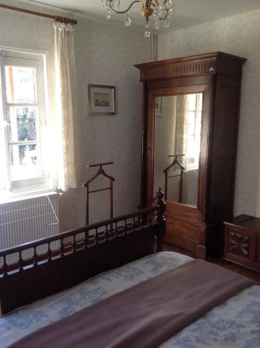 a bedroom with a bed with a wooden headboard and a window at Maison Lacoste in Campan