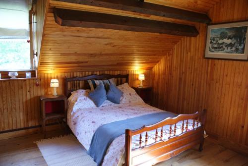 1 dormitorio con 1 cama en una habitación de madera en Maison Lacoste en Campan