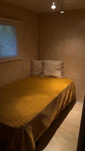 a bedroom with a bed in a room with a window at Casinha das bonecas in Adenodeiro