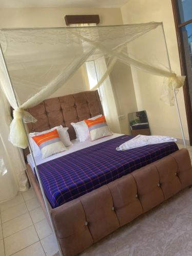 a large bed with a canopy in a bedroom at Pristine Home - Cozy Luxury Residence in Mtwapa