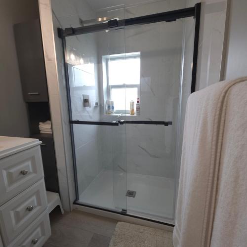a shower with a glass door in a bathroom at Endless Summer in Summerland