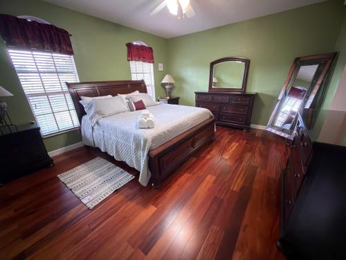 a bedroom with a large bed and a mirror at Acreage Oasis - 5 Bedrooms, Pool, Space, Serenity in West Palm Beach