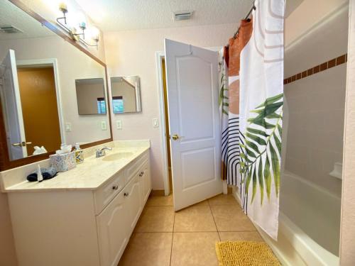a bathroom with a sink and a mirror at Acreage Oasis - 5 Bedrooms, Pool, Space, Serenity in West Palm Beach