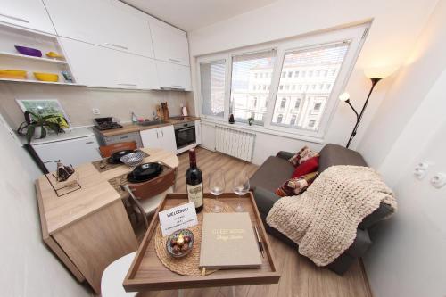 a living room with a couch and a table with a bottle of wine at Prime Main Square Location in Skopje