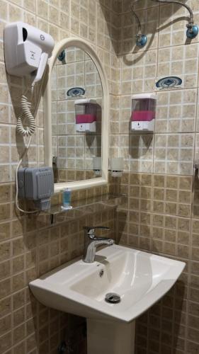 a bathroom with a sink and a mirror at شقق لافينا للوحدات السكنية - المخدومة - اقتصادي in Hail