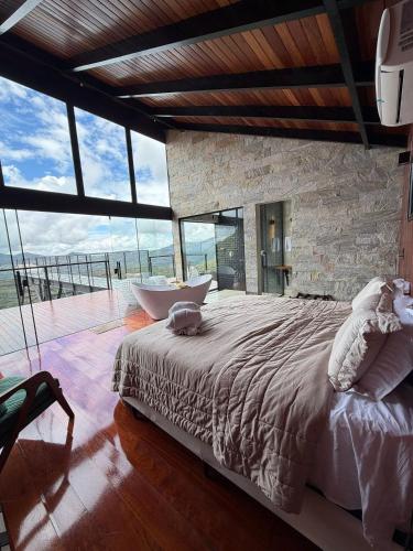 a bedroom with a large bed and a bath tub at Chalé A-Frame - Chalé de Cima in Ouro Preto