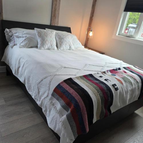 a bed with a white comforter and a blanket at Endless Summer in Summerland