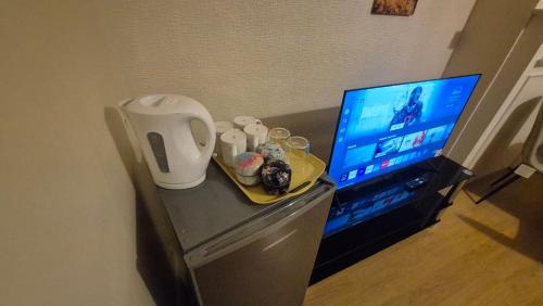 a desk with a television and a plate of food at The ultimate group stay in Catford