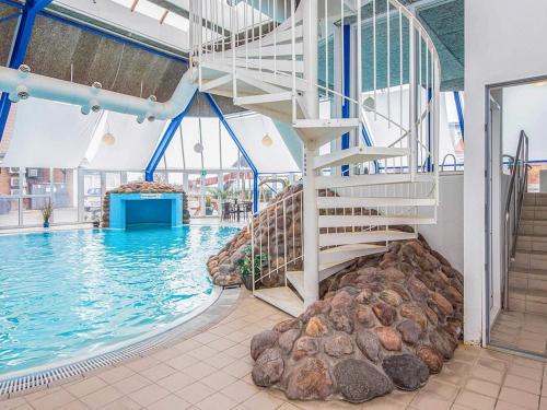 a swimming pool with a spiral staircase in a building at 4 person holiday home in Hejls-By Traum in Hejls