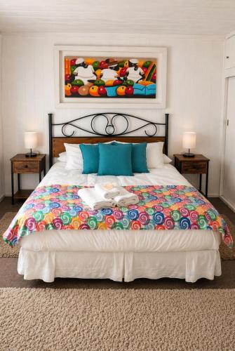 a bedroom with a large bed with a painting on the wall at Hostería Alemana in Villarrica