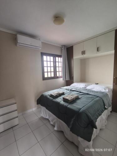a bedroom with a large bed and a window at Chalé Esmeralda in Gravatá