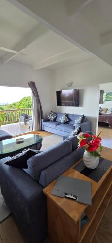 a living room with a blue couch and a table at Ocean Beach Town View - Pool With Amazing Views! in Rarotonga