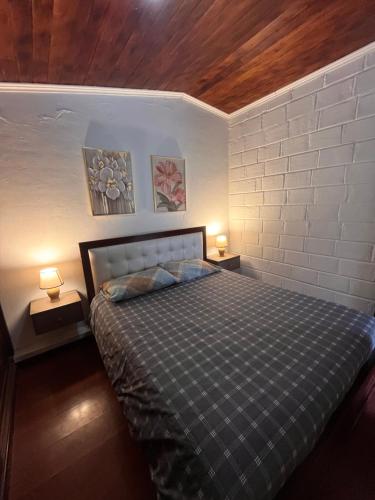 a bedroom with a bed with two lamps on both sides at Rincón de Paz y Tranquilidad in Ambato
