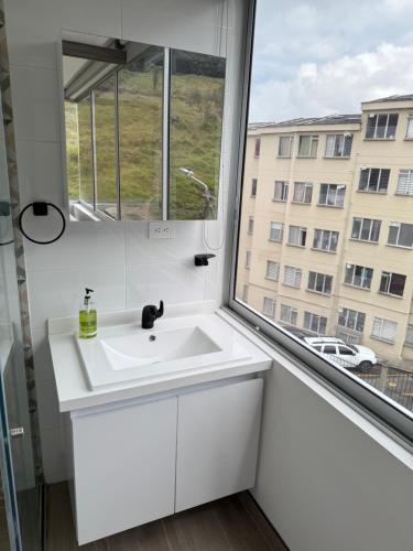 a bathroom with a white sink and a window at Casa Aurora in Manizales